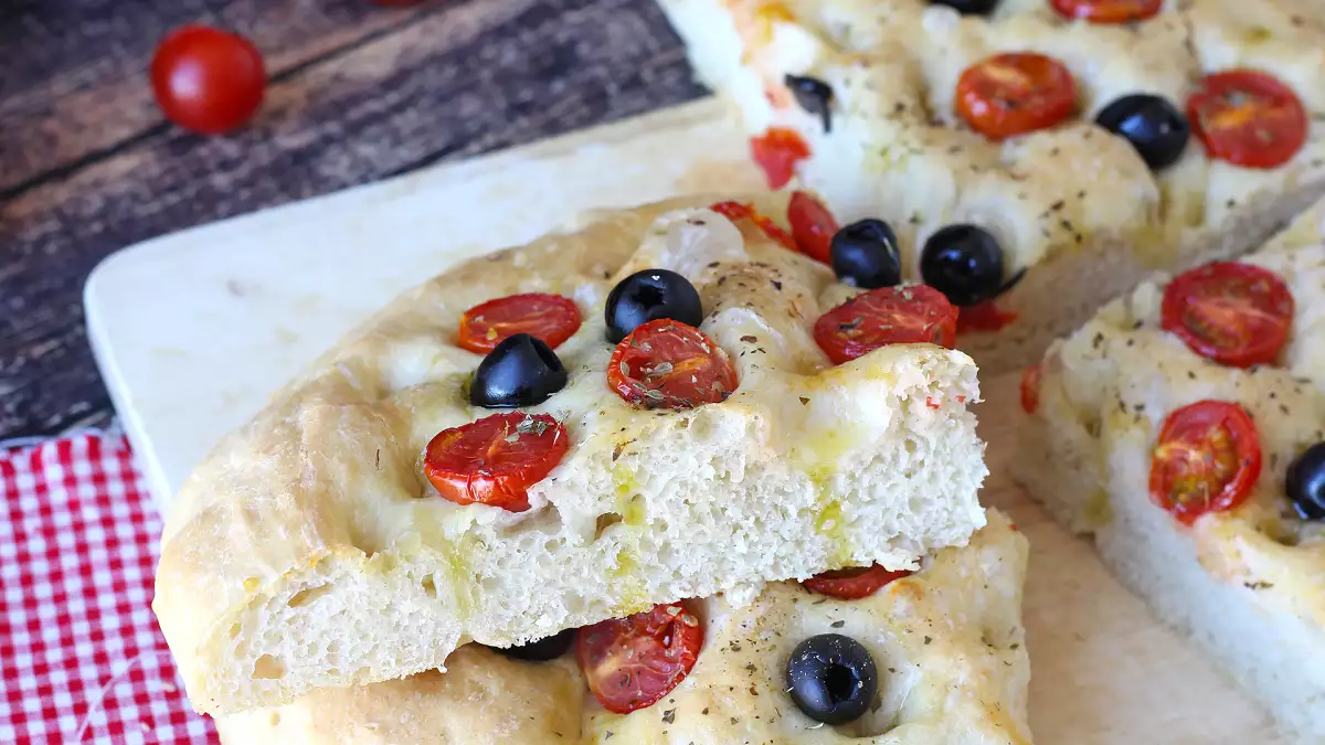 Denne tykke focaccia med cherrytomater og oliven vinder ens hjerte allerede med sin duft: en opskrift, du bør prøve