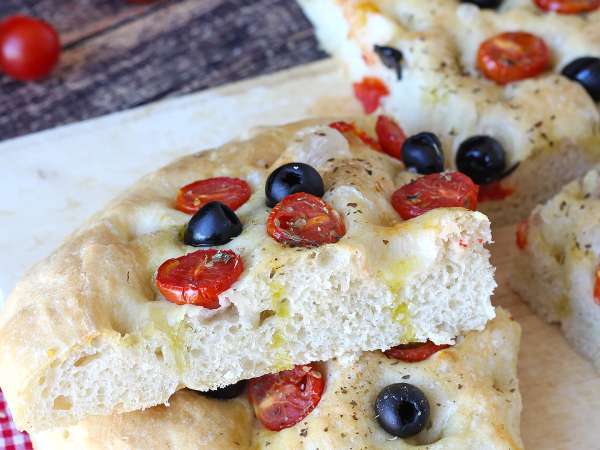 Denne høje focaccia med cherrytomater og oliven vinder dig over allerede med sin duft: en opskrift, du bør prøve